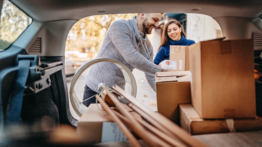 couple backing up their van with boxes for new apartment